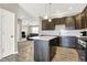Stylish kitchen boasts dark cabinets, a center island, and stainless steel appliances, offering a modern aesthetic at 2792 Maricopa Blvd, Whitestown, IN 46075
