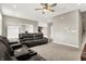 Open concept living room with neutral walls, carpeted floors, ceiling fan, and view to the kitchen at 2792 Maricopa Blvd, Whitestown, IN 46075