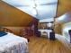 Wide angle view of a spacious room with wood paneled walls, featuring hardwood floors, bed and a leather chair at 3016 Sheridan St, Anderson, IN 46016