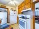 Well-equipped kitchen featuring white appliances, wood cabinets, and an adjacent door to the hallway at 3016 Sheridan St, Anderson, IN 46016