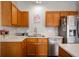 Close-up view of kitchen area with stainless steel appliances, oak cabinets, and efficient lighting at 307 Blue Spruce Dr, Pendleton, IN 46064