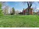 Spacious backyard with lush green grass and mature trees surrounding the home at 3376 Scramble Dr, Greenwood, IN 46143
