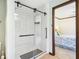 Modern bathroom featuring a glass-enclosed shower with tile surround, and a view into the bedroom at 3376 Scramble Dr, Greenwood, IN 46143