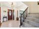 Inviting foyer featuring neutral tile flooring, a staircase, and a decorative wooden front door at 3376 Scramble Dr, Greenwood, IN 46143