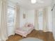 Sunlit bedroom with hardwood floors featuring two large windows and a cozy twin-sized bed at 4317 N Park Ave, Indianapolis, IN 46205