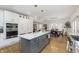 Open-concept kitchen with a gray island, white cabinets, stainless steel appliances, and hardwood floors at 4317 N Park Ave, Indianapolis, IN 46205