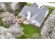 Aerial view of the home featuring a well-maintained yard, deck, stone patio, and mature trees at 5300 Breakers Way, Carmel, IN 46033