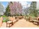 Spacious wooden deck with outdoor seating, a grill, and view of the blooming trees and backyard at 5300 Breakers Way, Carmel, IN 46033