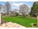 Lush green backyard with a wooden fence and mature trees, offering privacy and space at 5300 Breakers Way, Carmel, IN 46033