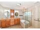 Elegant bathroom with double sinks, bathtub, glass enclosed shower, and a chandelier at 5300 Breakers Way, Carmel, IN 46033