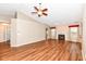 Cozy living room featuring hardwood floors, fireplace with white mantle, ceiling fan, and neutral walls at 5300 Breakers Way, Carmel, IN 46033