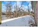 Backyard of a brick home with green trim, covered in winter snow at 60 Huddleston N Dr, Indianapolis, IN 46217