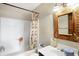 Bathroom featuring a bathtub, shower curtain, white sink, and a decorative mirror at 60 Huddleston N Dr, Indianapolis, IN 46217