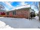 Back exterior view of a brick home with green trim and some snow in the yard at 60 Huddleston N Dr, Indianapolis, IN 46217
