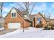 Charming brick home with an attached garage and snow-covered yard at 60 Huddleston N Dr, Indianapolis, IN 46217