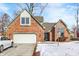Charming brick home with attached garage, set against a clear blue sky at 60 Huddleston N Dr, Indianapolis, IN 46217
