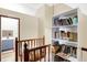 A hallway with wooden railing leads to a bathroom and a bookshelf at 60 Huddleston N Dr, Indianapolis, IN 46217