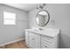 Bright bathroom features a modern vanity with white countertop and stylish round mirror at 6205 Beech Grove Rd, Martinsville, IN 46151