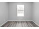 Bedroom with a large window providing natural light and newly installed grey floors at 6205 Beech Grove Rd, Martinsville, IN 46151