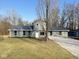 Charming single-story home with a metal roof, gray siding, a gravel driveway, and a well-manicured lawn at 6205 Beech Grove Rd, Martinsville, IN 46151