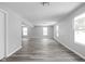 Spacious living room with large windows and gray woodgrain laminate flooring at 6205 Beech Grove Rd, Martinsville, IN 46151