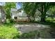 View of a house with a wooden deck and gravel area, surrounded by trees and a chainlink fence at 633 E 32Nd St, Indianapolis, IN 46205