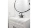 Modern bathroom sink with black fixtures and a minimalist round mirror at 633 E 32Nd St, Indianapolis, IN 46205