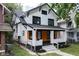 Charming two-story home with a front porch featuring wood accents and a manicured lawn at 633 E 32Nd St, Indianapolis, IN 46205