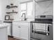 Bright kitchen with white cabinets, stainless steel appliances, undermount sink, and floating shelves at 633 E 32Nd St, Indianapolis, IN 46205