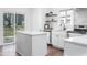 Modern white kitchen features a kitchen island, stainless steel appliances, and sliding glass doors at 633 E 32Nd St, Indianapolis, IN 46205