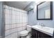 Cozy bathroom featuring a shower with a stylish striped curtain, a modern vanity, and blue painted walls at 6348 Bay Vista E Dr, Indianapolis, IN 46250