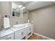 Bathroom with double sinks, white cabinets, modern fixtures, and hardwood floors at 6348 Bay Vista E Dr, Indianapolis, IN 46250