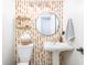 Stylish half-bathroom with pedestal sink, decorative shelves, and bold patterned wallpaper at 6348 Bay Vista E Dr, Indianapolis, IN 46250