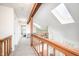 Bright hallway with wooden railing, textured ceiling, and skylights providing ample natural light at 6348 Bay Vista E Dr, Indianapolis, IN 46250