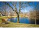 Scenic view of a tranquil pond surrounded by trees, featuring a bench for peaceful contemplation at 6348 Bay Vista E Dr, Indianapolis, IN 46250