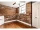 Bedroom featuring exposed brick wall, hardwood floors, and ceiling fan at 643 Fort Wayne Ave # B & D, Indianapolis, IN 46204