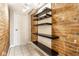 Hallway with red brick wall, floating black shelves, and door at 643 Fort Wayne Ave # B & D, Indianapolis, IN 46204