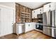 Modern kitchen featuring stainless steel appliances, white cabinetry, and exposed brick at 643 Fort Wayne Ave # B & D, Indianapolis, IN 46204