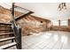 Spacious living room with spiral staircase, white tile floors, and exposed brick walls at 643 Fort Wayne Ave # B & D, Indianapolis, IN 46204
