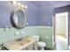 This bathroom features pastel tiling, vanity, and an oval mirror at 6838 Hague Rd, Indianapolis, IN 46256