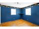 This bedroom has blue walls, hardwood floors, and windows that let in natural light at 6838 Hague Rd, Indianapolis, IN 46256