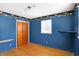 A bedroom with blue walls, hardwood floors, closet and shelf at 6838 Hague Rd, Indianapolis, IN 46256