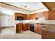 View of kitchen, showcasing wood cabinets, sink, countertop space, and access to other areas of the house at 6838 Hague Rd, Indianapolis, IN 46256