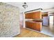 Open kitchen and living room layout with wood cabinets and stone wall detailing, ready for updates at 6838 Hague Rd, Indianapolis, IN 46256