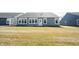 A well-kept backyard showcasing a gray house with a bright window and door design and healthy green grass at 720 Keck Way, Westfield, IN 46074