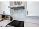 Close-up of a modern kitchen with stainless steel range hood and gas cooktop at 720 Keck Way, Westfield, IN 46074