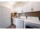 Well-lit laundry room featuring full-size washer and dryer, sink, and modern white cabinetry at 720 Keck Way, Westfield, IN 46074