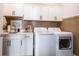 Bright laundry room featuring white cabinets, countertop, sink, washer, and dryer for efficient home chores at 720 Keck Way, Westfield, IN 46074