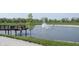 A scenic pond featuring a charming bridge and water fountain surrounded by green grass and mature trees at 720 Keck Way, Westfield, IN 46074