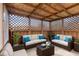Stylishly furnished gazebo interior with seating, coffee table, and lattice windows that provide natural light at 7579 Allenwood Ct, Indianapolis, IN 46268